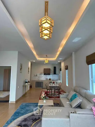 Spacious modern living room with elegant lighting and open kitchen layout