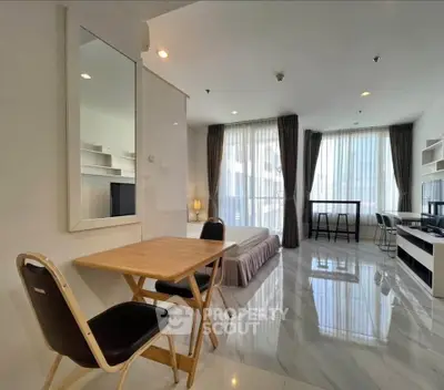 Spacious modern studio apartment with elegant decor and large windows for natural light.