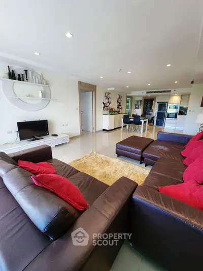 Spacious modern living room with leather sofas and open kitchen layout