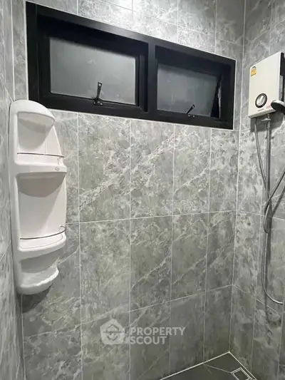 Modern bathroom with sleek gray tiles and shower unit