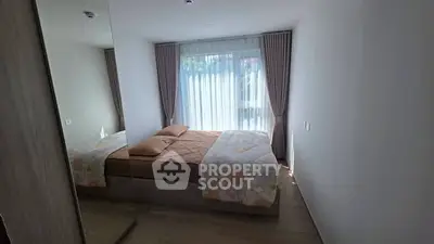 Cozy bedroom with large window and elegant curtains, perfect for relaxation.