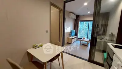 Modern apartment interior with open layout, featuring dining area and living room with city view.
