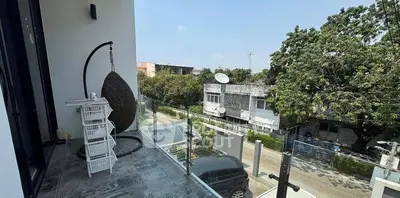 Spacious balcony with modern glass railing and scenic neighborhood view