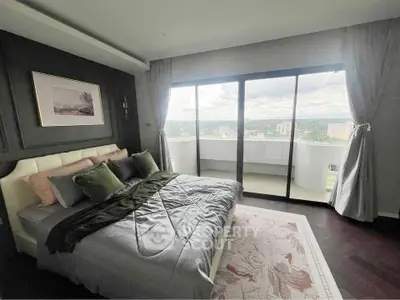 Luxurious bedroom with large windows and balcony offering stunning city views.