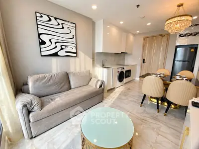 Modern living room with elegant decor, featuring a cozy sofa, dining area, and sleek kitchen appliances.