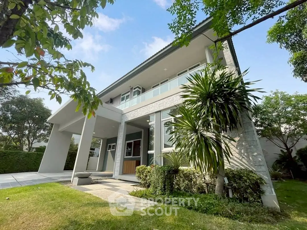 Modern two-story house with lush garden and contemporary design, perfect for family living.
