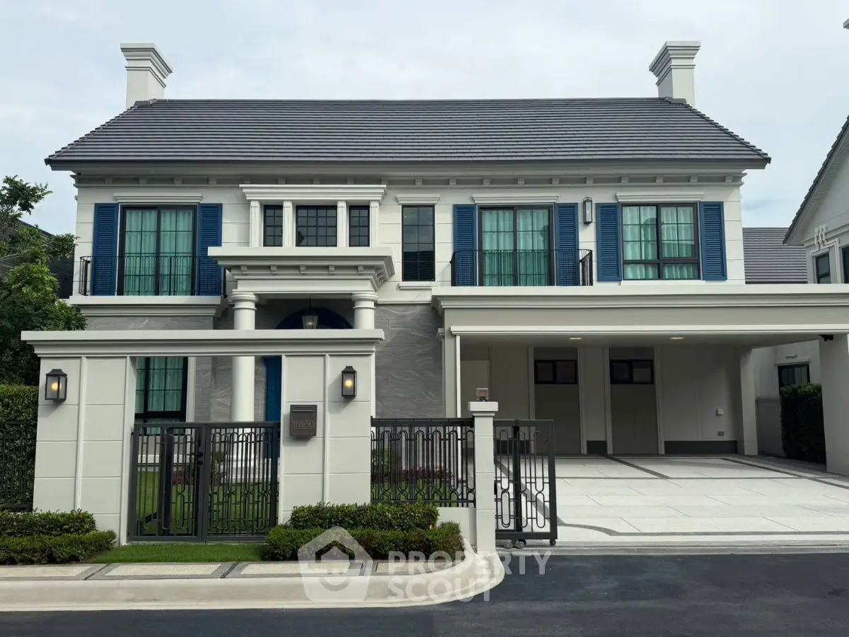 Elegant two-story house with blue shutters and spacious driveway