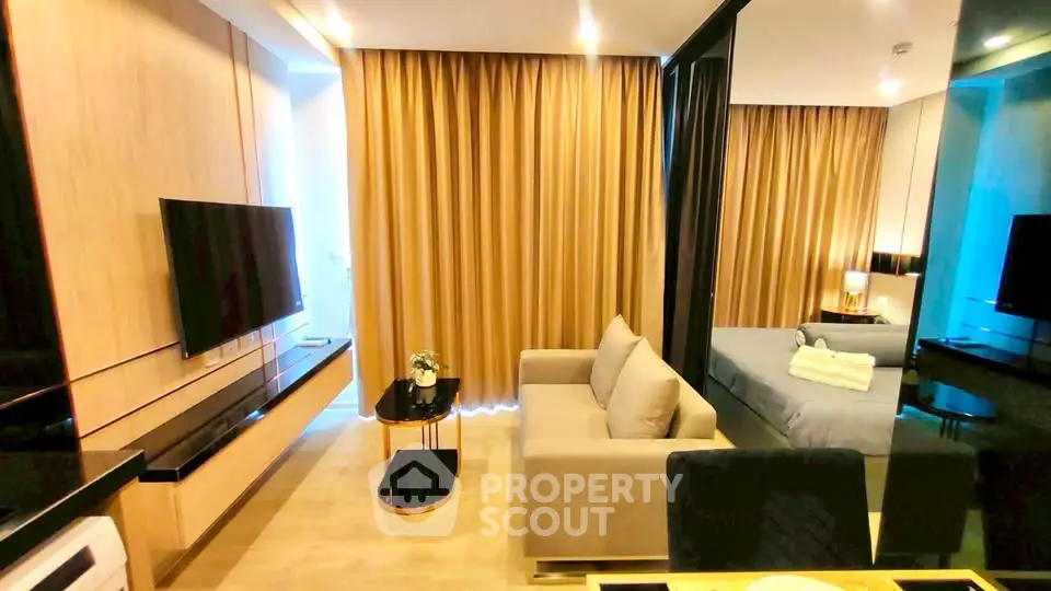 Modern open-plan living room with sleek design and cozy bedroom area, perfect for urban living.