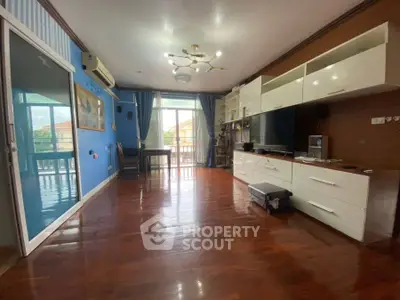 Spacious living room with wooden flooring and modern entertainment unit.