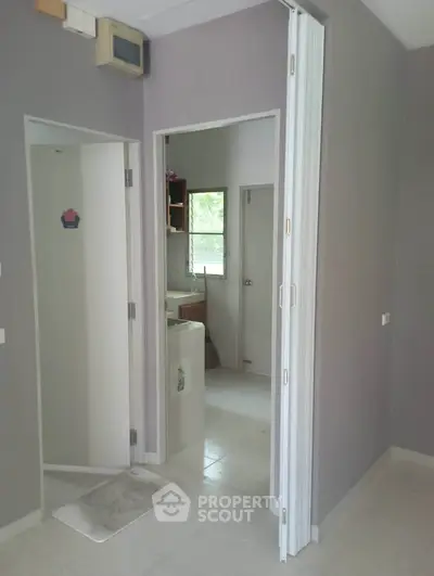 Modern interior with folding door and neutral tones, featuring a compact laundry area.