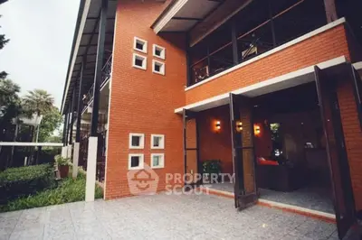Modern brick exterior with open patio doors and lush greenery, perfect for stylish living.