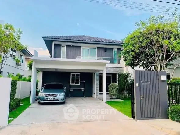Modern two-story house with carport and lush garden in a serene neighborhood.