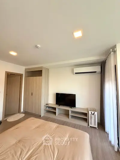Modern bedroom with air conditioning and sleek TV setup, featuring minimalist design and cozy ambiance.