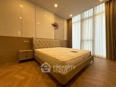 Spacious bedroom with elegant design and large windows for natural light.