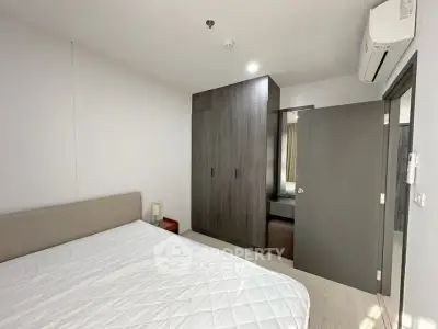 Modern bedroom with built-in wardrobe and air conditioning in a stylish apartment.