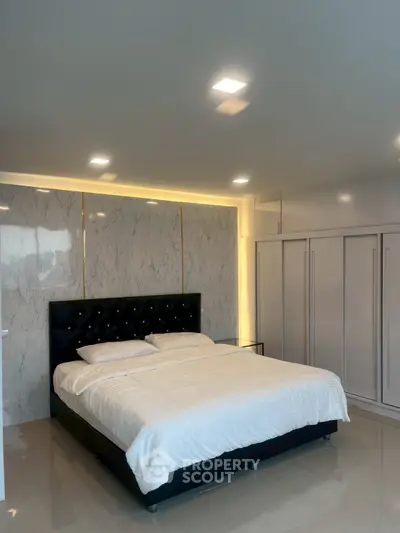 Luxurious bedroom with elegant marble accent wall and modern lighting