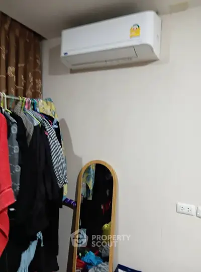 Cozy bedroom with air conditioning and clothes rack, ideal for comfortable living.