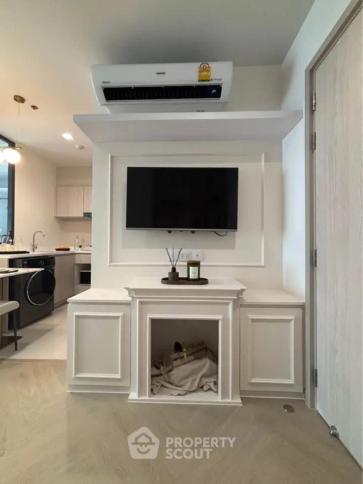 Modern living room with sleek TV setup and stylish kitchen in open layout