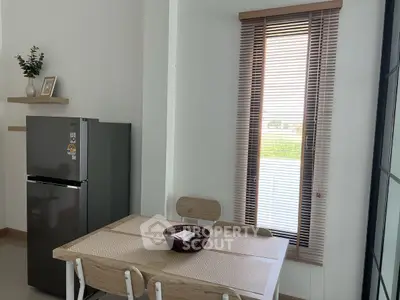 Modern kitchen with sleek fridge and cozy dining area by a window