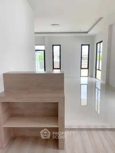 Spacious modern interior with sleek flooring and large windows for natural light.