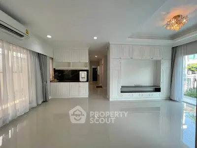 Spacious modern living room with elegant white cabinetry and large windows for natural light.