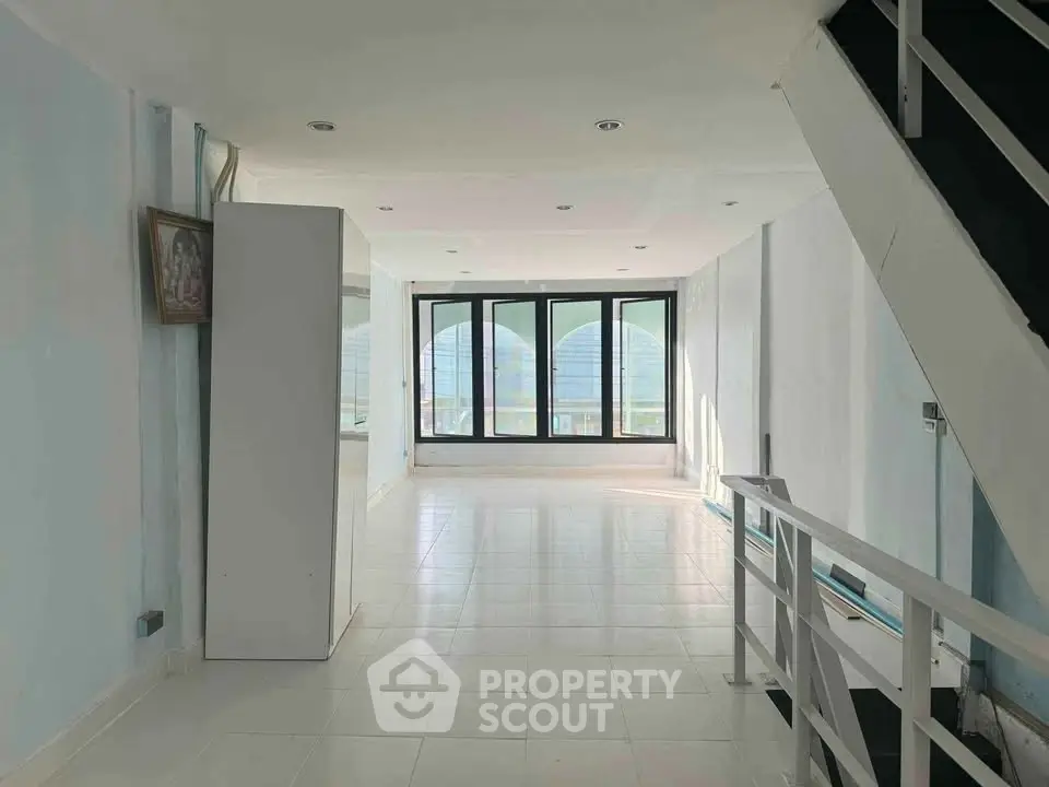 Spacious interior with large windows and modern staircase, perfect for urban living.
