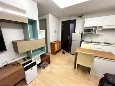 Modern compact kitchen and living area with sleek cabinetry and cozy dining space.