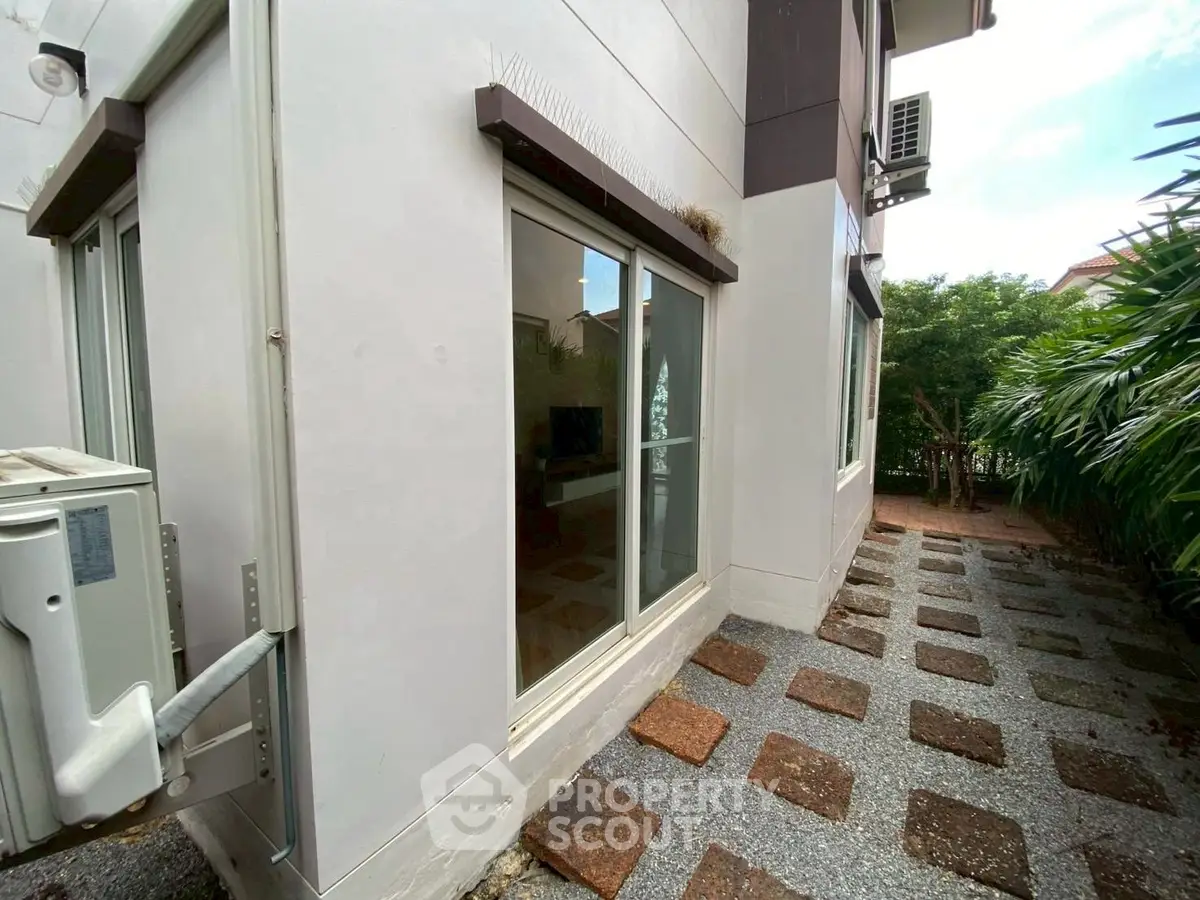 Charming exterior view of modern home with garden path and large windows