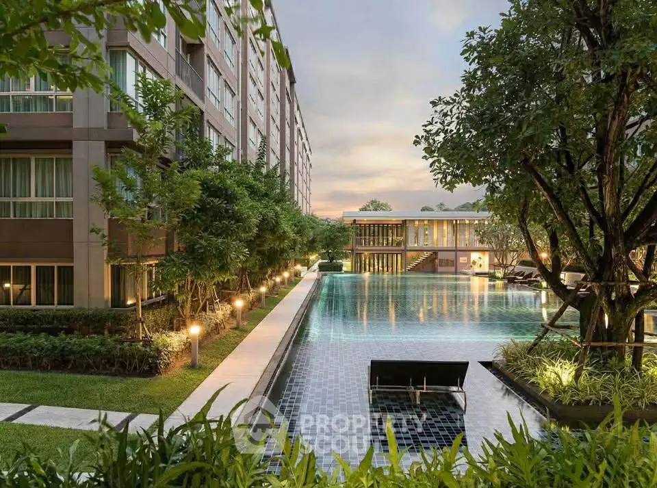 Luxurious apartment complex with stunning pool and lush garden view at sunset.