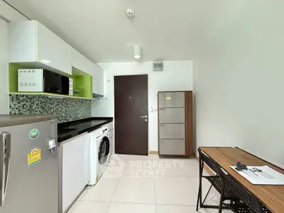 Modern kitchen with sleek appliances and stylish cabinetry in a compact layout.