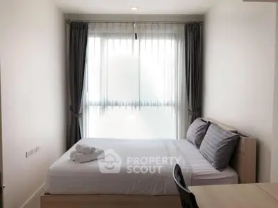 Cozy bedroom with natural light and modern furnishings in a stylish apartment.