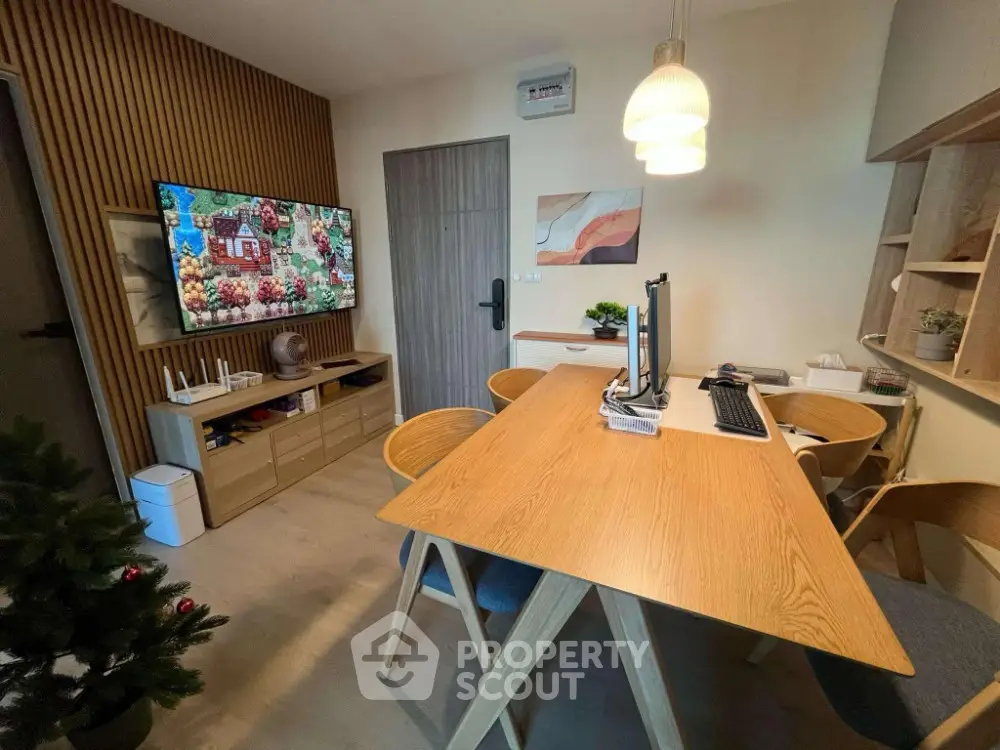 Modern study room with wooden furniture and wall-mounted TV, ideal for work and relaxation.