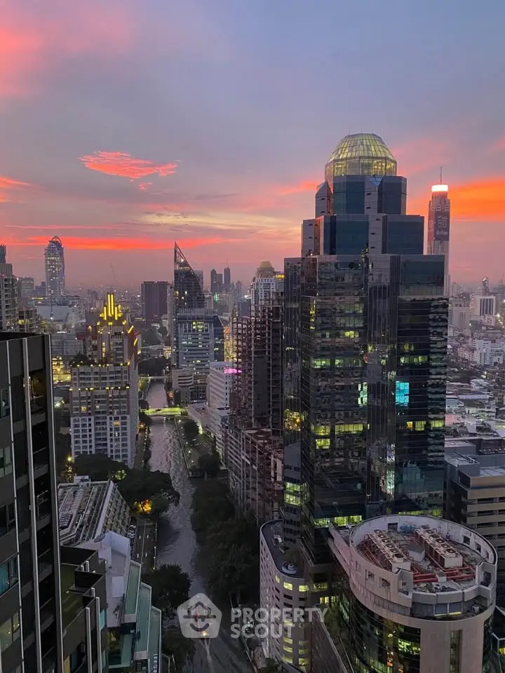 Stunning cityscape view from a high-rise building at sunset, showcasing urban skyline and vibrant sky.