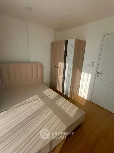 Cozy bedroom with natural light, featuring a stylish bed and modern wardrobe, perfect for relaxation.
