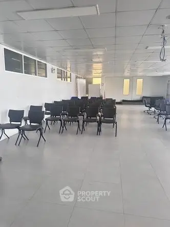 Spacious modern office space with rows of chairs and bright lighting.