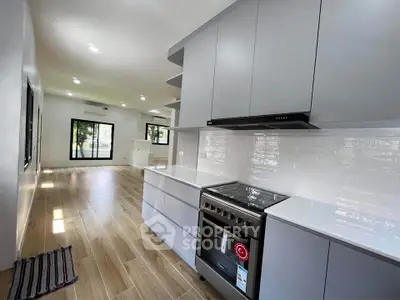 Modern open-plan kitchen with sleek cabinetry and stainless steel appliances in a bright, spacious interior.