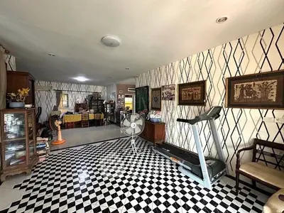 Spacious living room with unique checkered flooring and treadmill, perfect for relaxation and exercise.