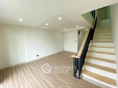 Spacious modern living room with elegant staircase and wooden flooring