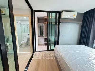 Modern bedroom with ensuite bathroom and large glass doors in a stylish apartment.