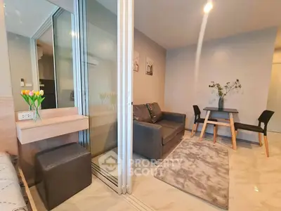 Modern living room with cozy seating and dining area, featuring elegant decor and natural lighting.