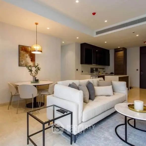 Modern living room with open kitchen, stylish decor, and cozy seating area in a contemporary apartment.
