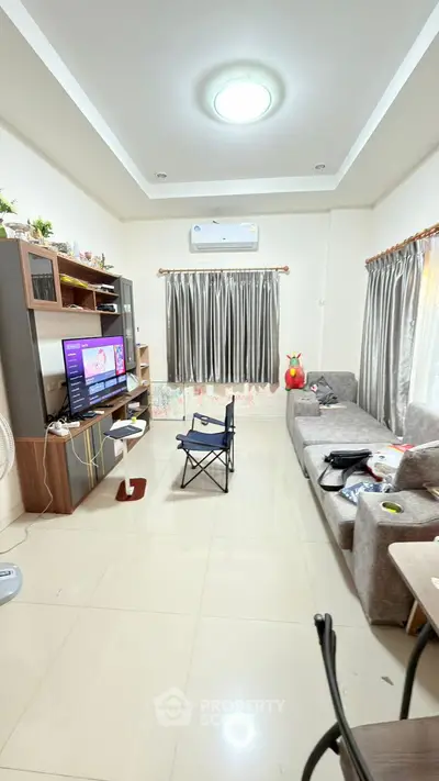 Spacious living room with modern decor and natural light, perfect for relaxation and entertainment.