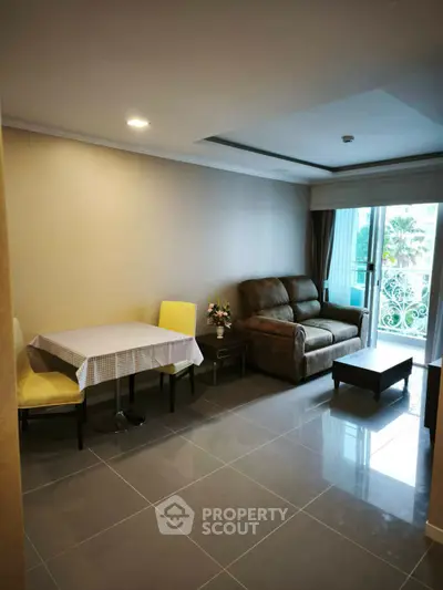 Cozy living room with modern furnishings and balcony access in a stylish apartment.