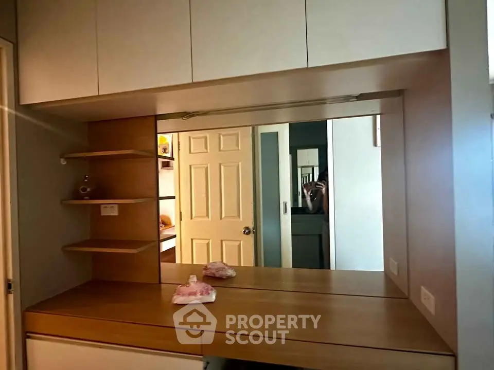 Modern bedroom with built-in wooden vanity and mirror, showcasing sleek storage solutions.