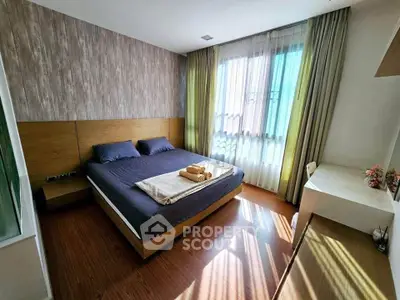 Spacious bedroom with modern decor and large window for natural light