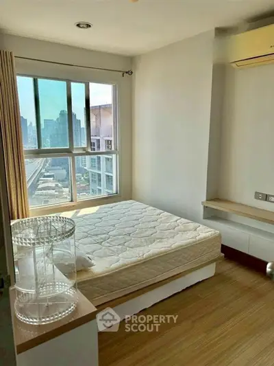 Bright bedroom with city view, featuring a comfortable bed and modern design.