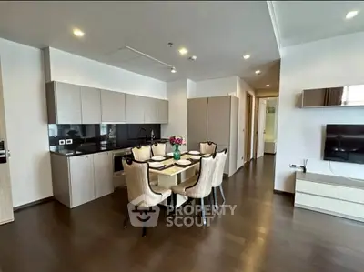 Modern open-layout kitchen and dining area with sleek cabinetry and elegant dining set.