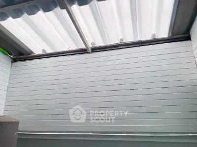 Modern industrial-style interior with corrugated metal ceiling and sleek panel walls.