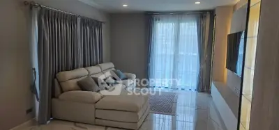 Spacious modern living room with elegant sofa and large windows for natural light.