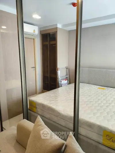Modern bedroom with glass partition and cozy furnishings in a stylish apartment.